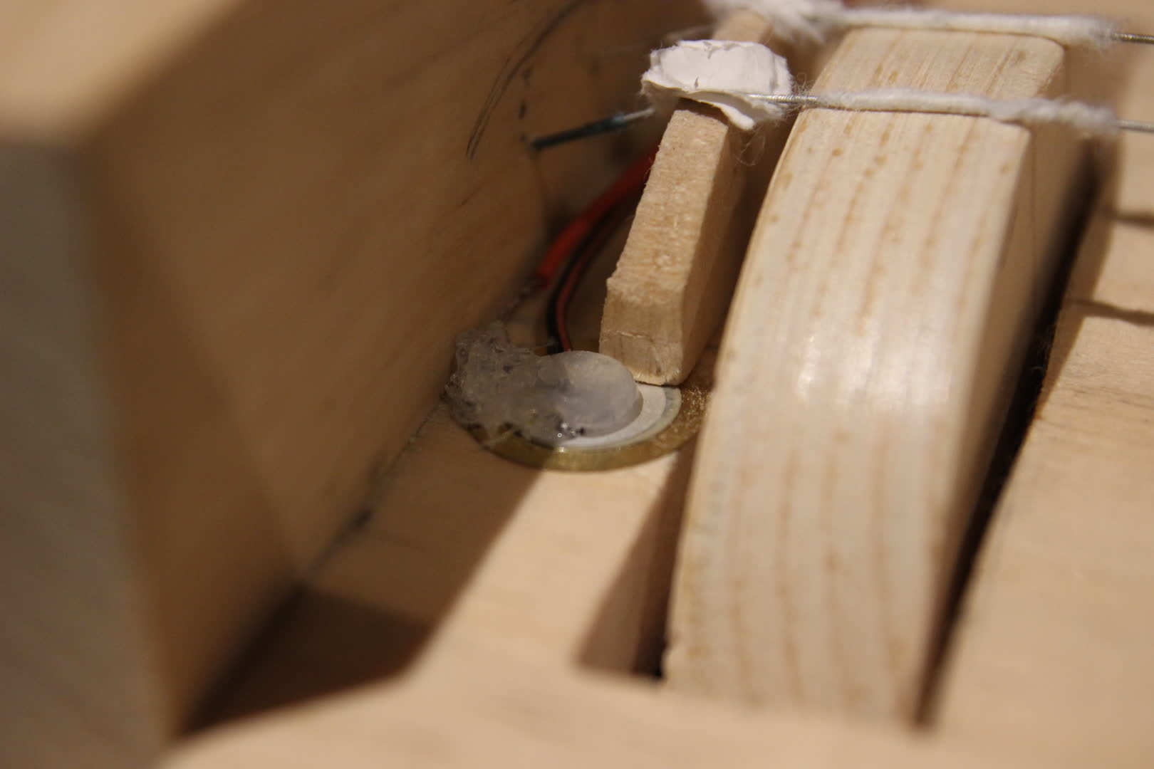 Close up of the piezo disk under the bridge.